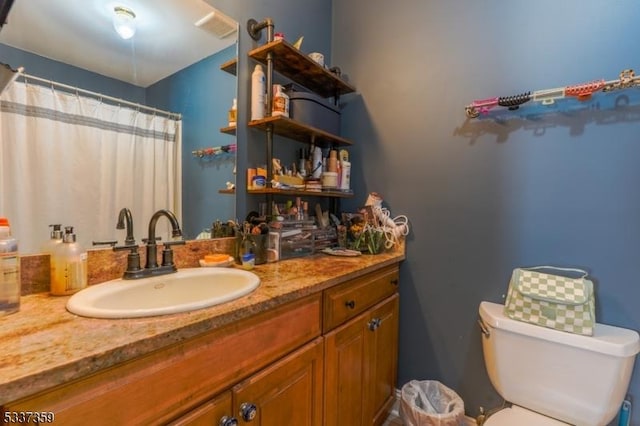 bathroom featuring toilet, visible vents, and vanity