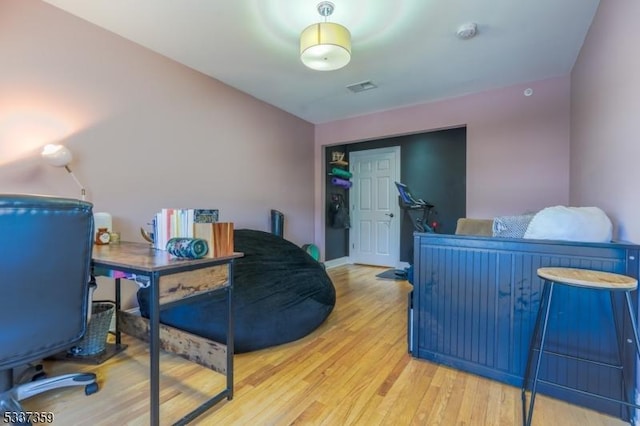 office with light wood-style flooring, visible vents, and baseboards