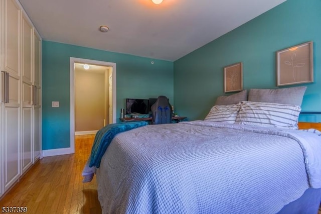 bedroom with light wood-style flooring and baseboards