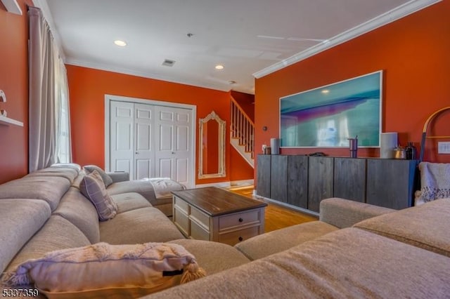 living room with recessed lighting, crown molding, and light wood finished floors