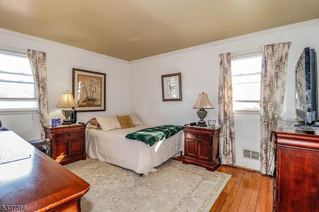 bedroom featuring ornamental molding and light wood-type flooring