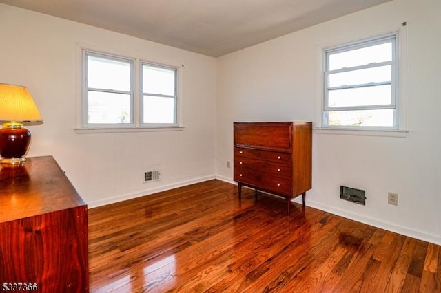 bedroom featuring multiple windows and dark hardwood / wood-style floors