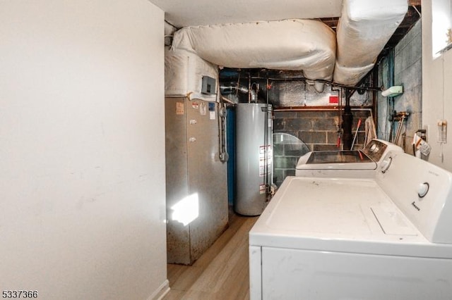 laundry room featuring light wood-type flooring, water heater, and washer and clothes dryer