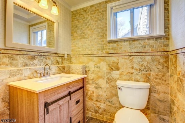 bathroom with vanity, ornamental molding, tile walls, and toilet