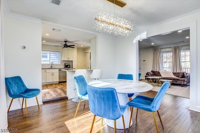 dining room featuring ceiling fan with notable chandelier, ornamental molding, dark hardwood / wood-style floors, and sink