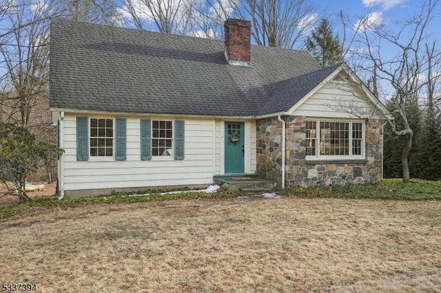 view of front of house with stone siding, roof with shingles, and a chimney