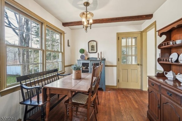 dining area featuring dark wood-style floors, a chandelier, and beamed ceiling