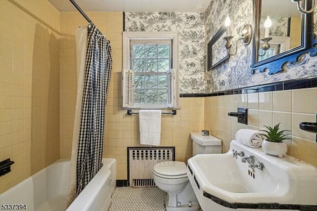 bathroom with toilet, radiator heating unit, wainscoting, a sink, and wallpapered walls