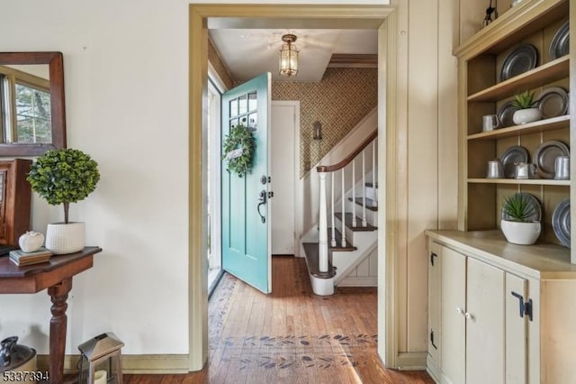 entrance foyer with light wood-style floors, stairs, and wallpapered walls