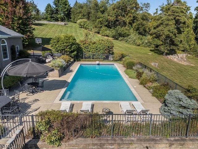 view of pool featuring a lawn and a patio