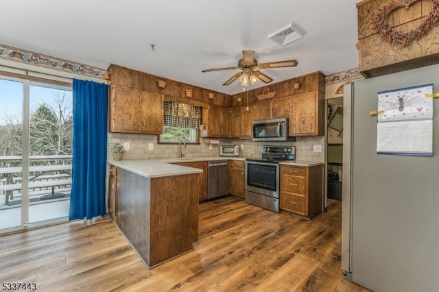 kitchen with dark hardwood / wood-style flooring, plenty of natural light, and appliances with stainless steel finishes