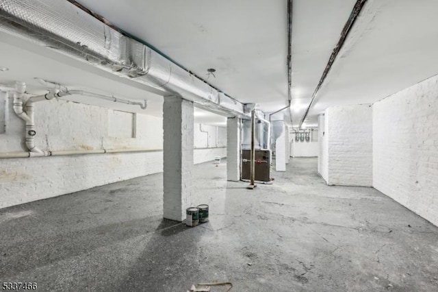 basement with brick wall and heating unit