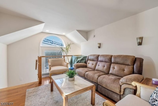 living room featuring lofted ceiling and light hardwood / wood-style floors