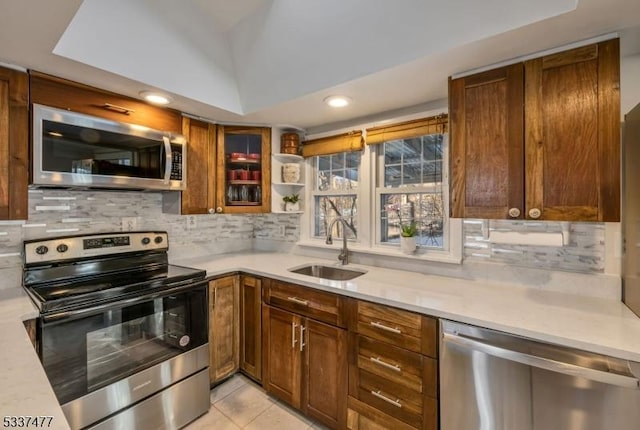 kitchen with light tile patterned floors, appliances with stainless steel finishes, sink, and backsplash