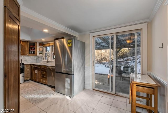 kitchen with crown molding, stainless steel appliances, decorative backsplash, and light tile patterned floors