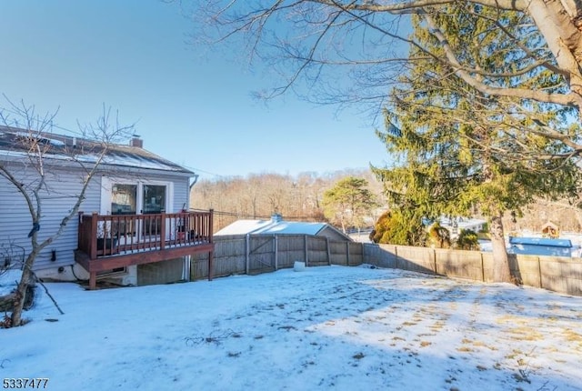 yard covered in snow with a deck