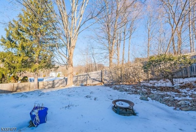 yard layered in snow featuring a fire pit