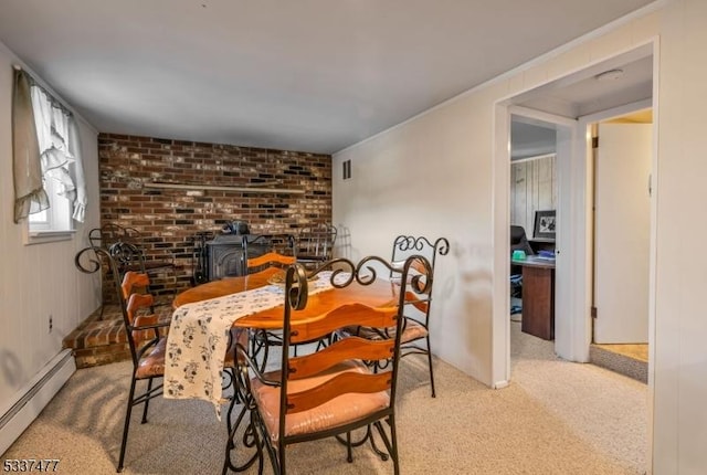 carpeted dining area with a baseboard heating unit