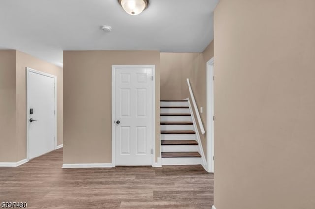 staircase with baseboards and wood finished floors