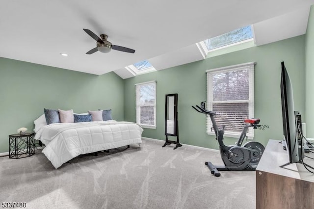 bedroom featuring lofted ceiling with skylight, carpet, ceiling fan, and baseboards