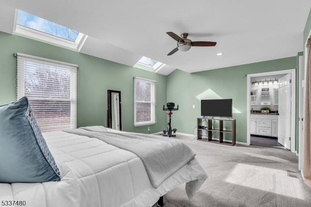 bedroom with vaulted ceiling with skylight, multiple windows, carpet flooring, and baseboards