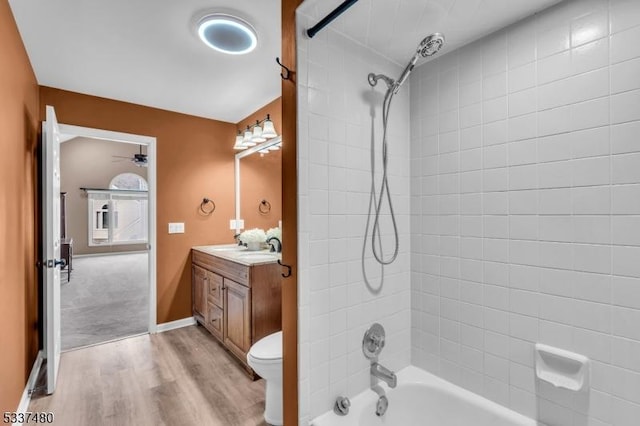 bathroom featuring bathing tub / shower combination, toilet, vanity, wood finished floors, and baseboards