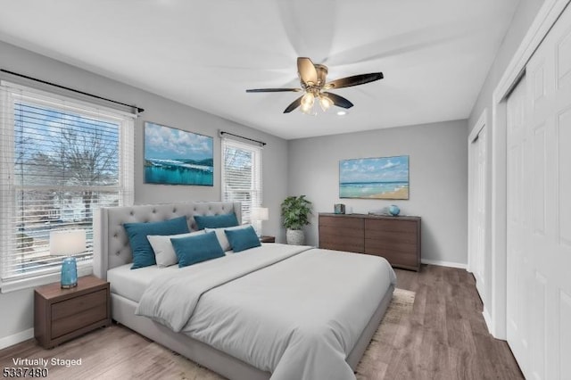 bedroom featuring a ceiling fan, baseboards, and wood finished floors