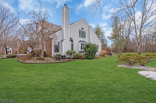 view of side of property with a yard and a chimney