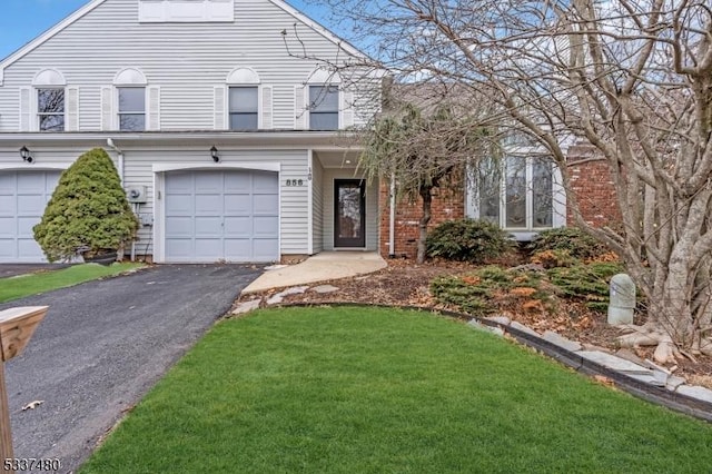 view of front of house featuring aphalt driveway, a front yard, and an attached garage