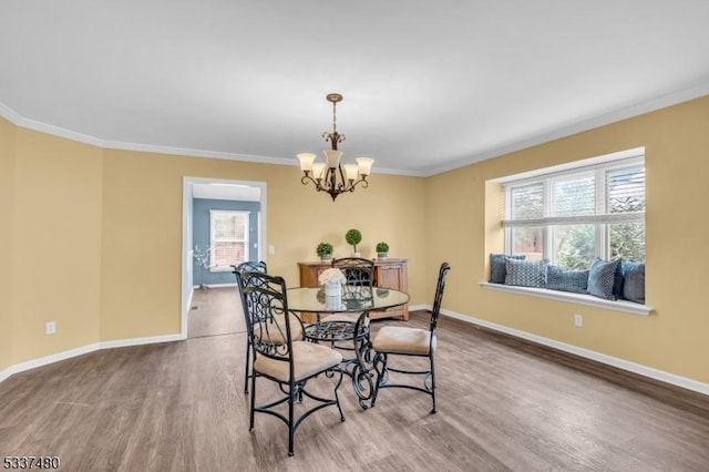 dining room with ornamental molding, wood finished floors, and baseboards