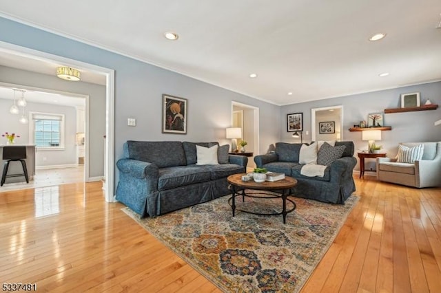 living room with crown molding and light hardwood / wood-style flooring