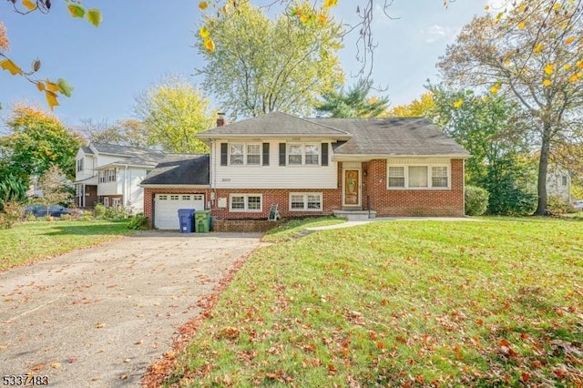 split level home with a garage and a front lawn