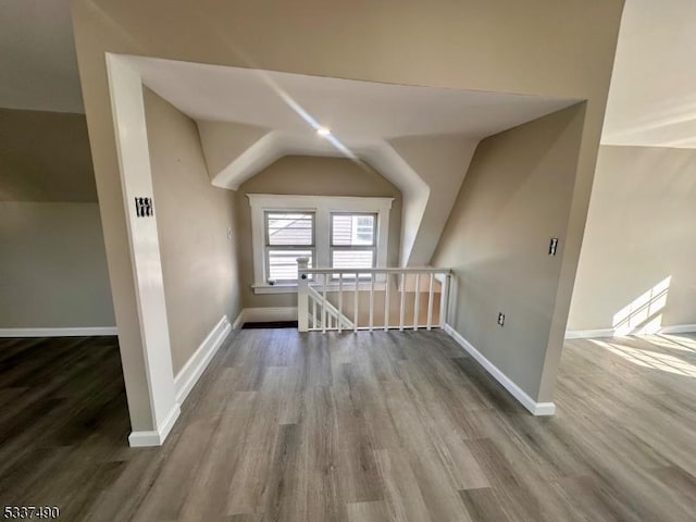 bonus room with vaulted ceiling, baseboards, and wood finished floors