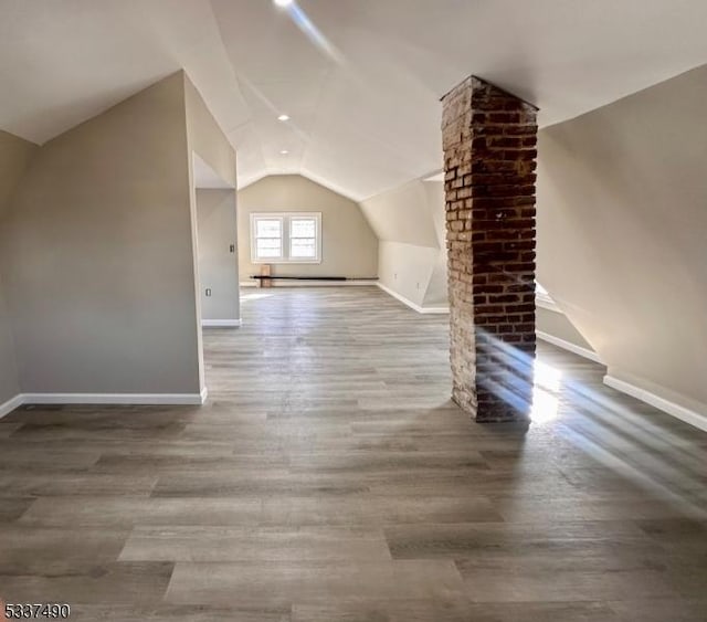 bonus room with lofted ceiling, wood finished floors, and baseboards