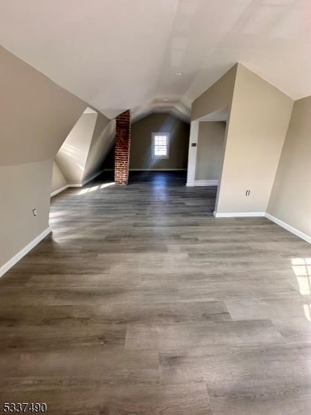 bonus room featuring lofted ceiling, baseboards, and wood finished floors