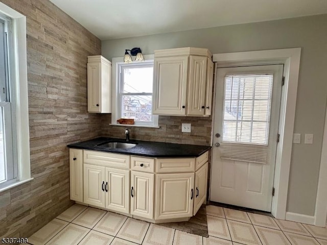 kitchen with dark countertops, a sink, and light tile patterned flooring