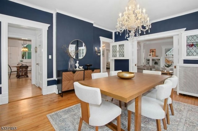 dining room featuring crown molding, a notable chandelier, and wood-type flooring