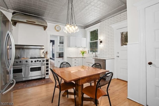 dining area with light hardwood / wood-style floors and brick wall