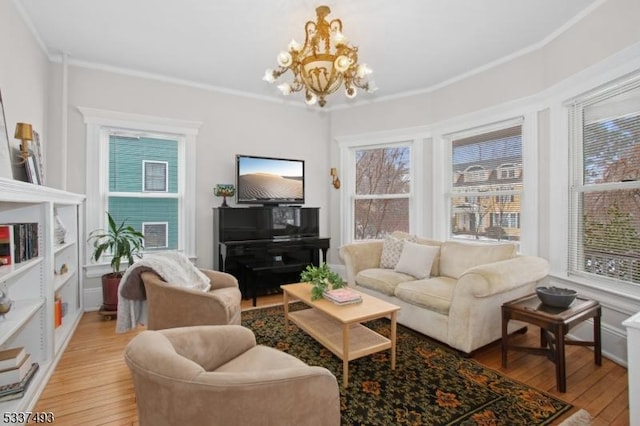 living room with light wood-type flooring, crown molding, and a chandelier