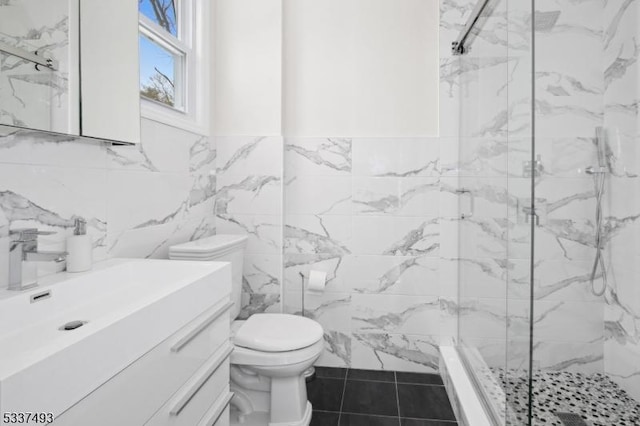 bathroom featuring tile walls, toilet, vanity, and walk in shower