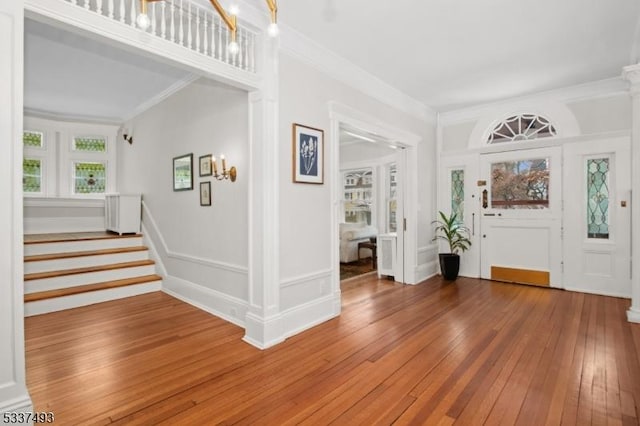 foyer entrance with hardwood / wood-style flooring and crown molding