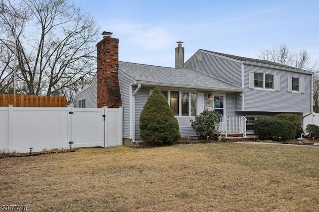 view of front facade featuring a gate, fence, a front lawn, and roof with shingles