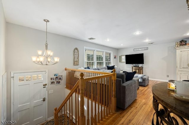 living room with an inviting chandelier and light wood-type flooring