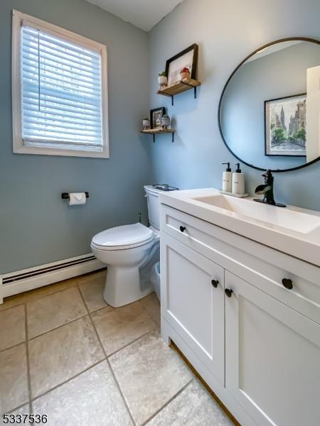 bathroom with vanity, tile patterned flooring, a baseboard radiator, and toilet