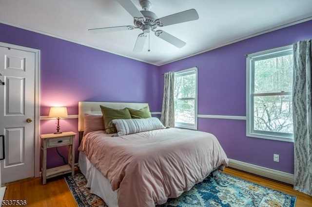 bedroom featuring hardwood / wood-style flooring, ceiling fan, and ornamental molding