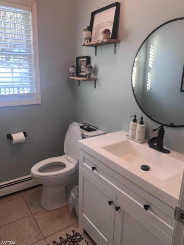 bathroom with baseboard heating, vanity, toilet, and tile patterned flooring