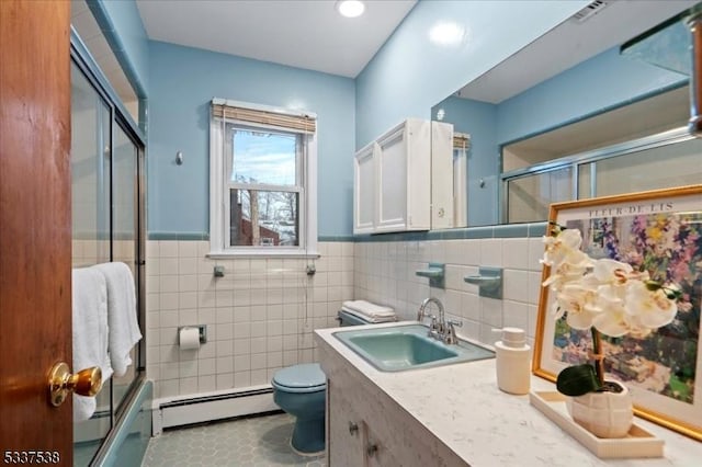 bathroom with vanity, tile walls, toilet, and baseboard heating