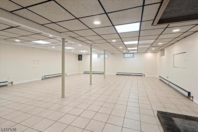 basement featuring a baseboard radiator and a drop ceiling