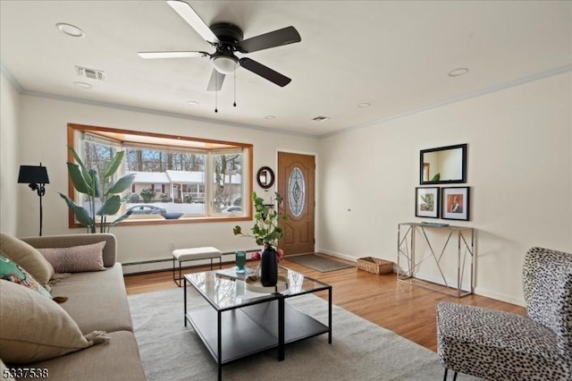 living room featuring ceiling fan, ornamental molding, light hardwood / wood-style floors, and a baseboard radiator