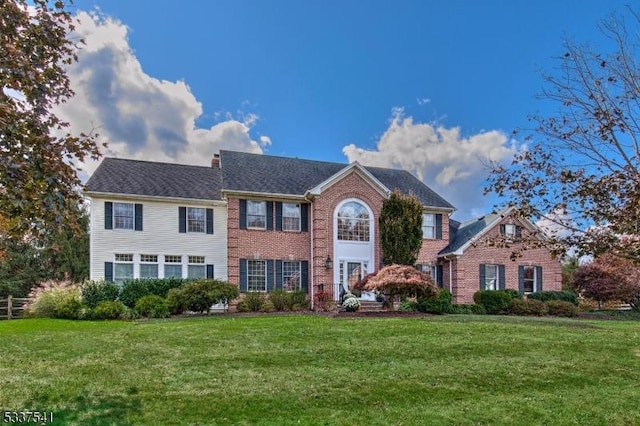 colonial house with brick siding and a front lawn